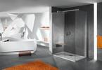 Asymetryczna wanna na tle futurystycznej aranżacji łazienki